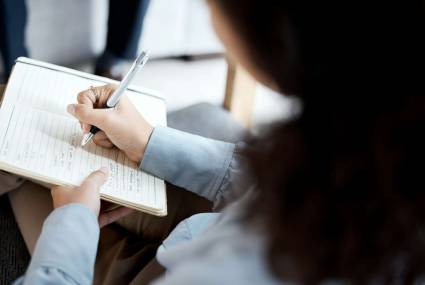 Psychologist hands, notebook and writing in therapy, counseling or psychology consultation. Therapi